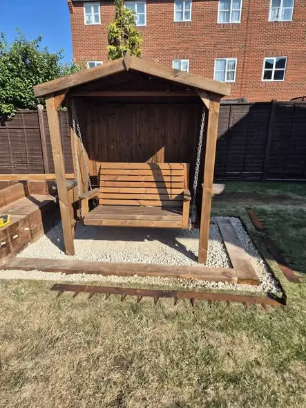 Covered garden swing seat on a gravel base