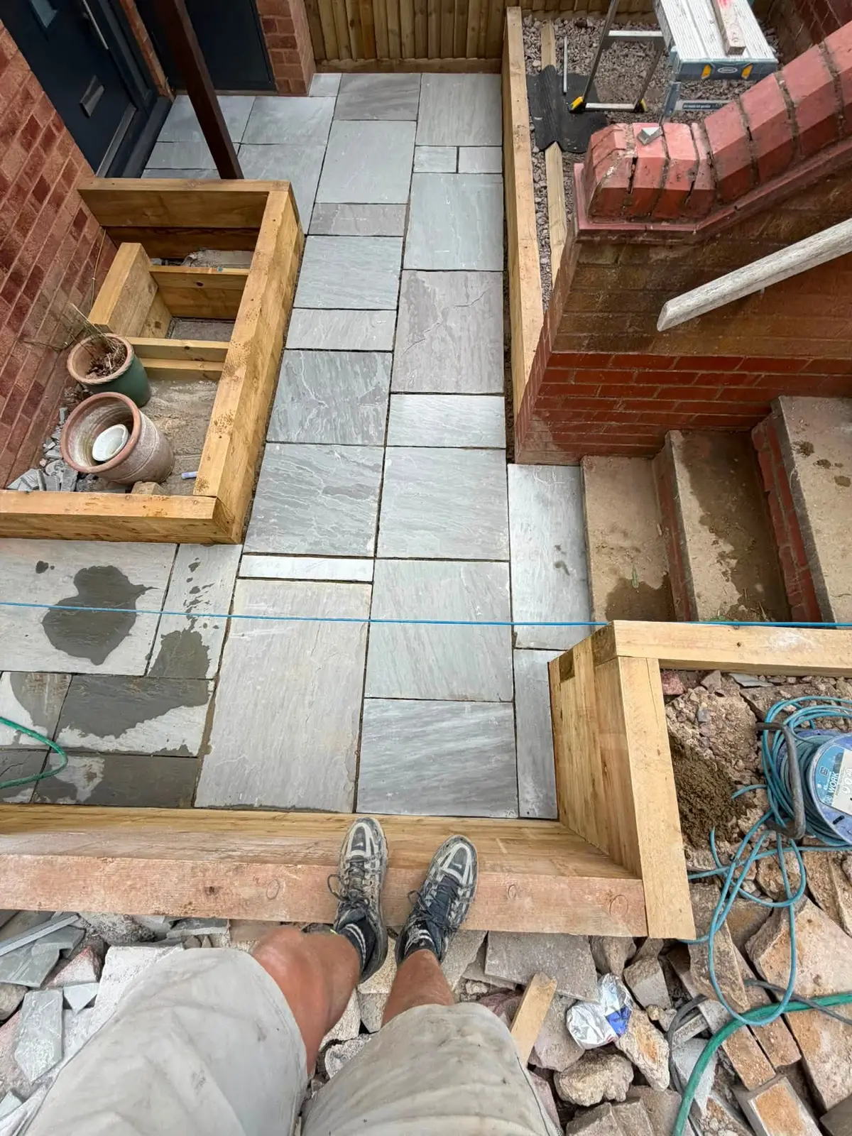Sandstone patio and brick steps mid-build